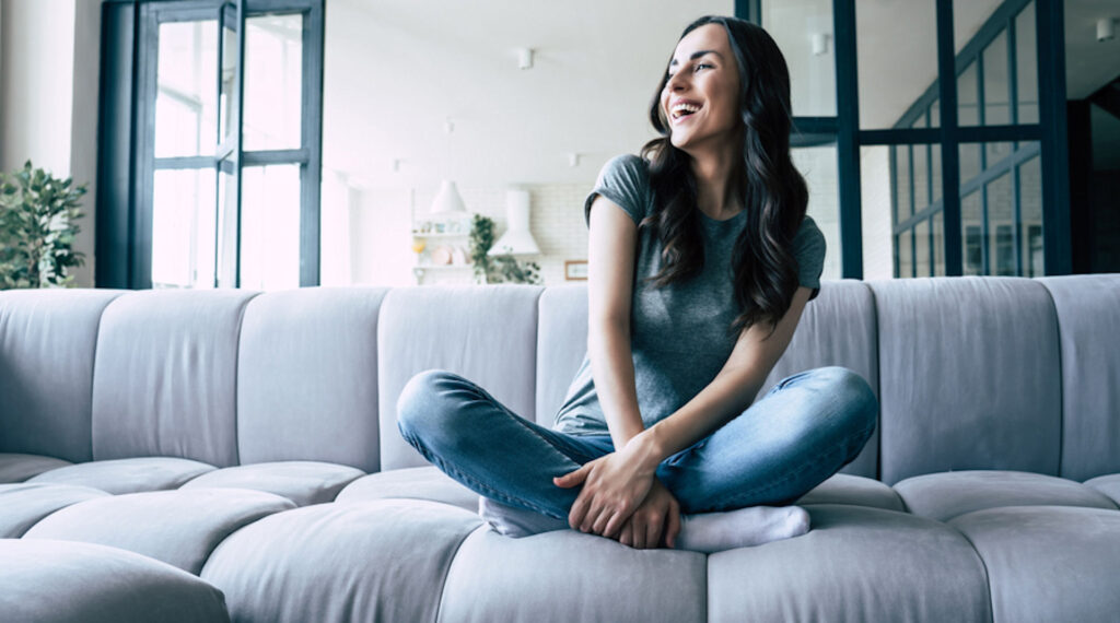 happy woman sitting on couch