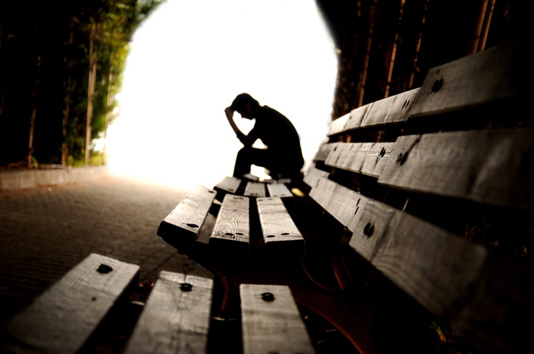 Man sitting on a bench managing his co-occurring mood disorders
