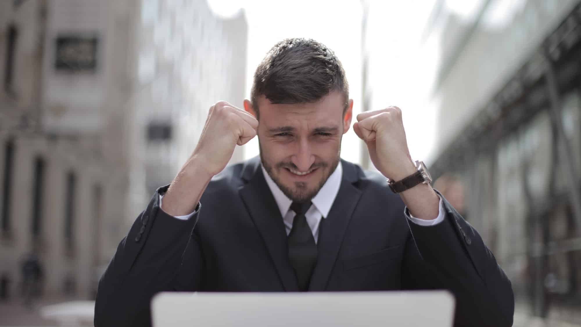 man smiling in front of laptop feeling confident after treatment