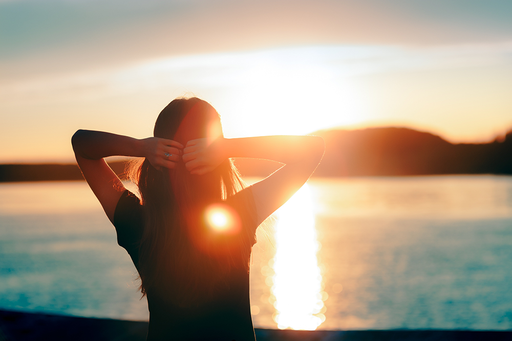 Woman in Orange County reflecting quietly in nature, representing the challenges of living with anxiety.