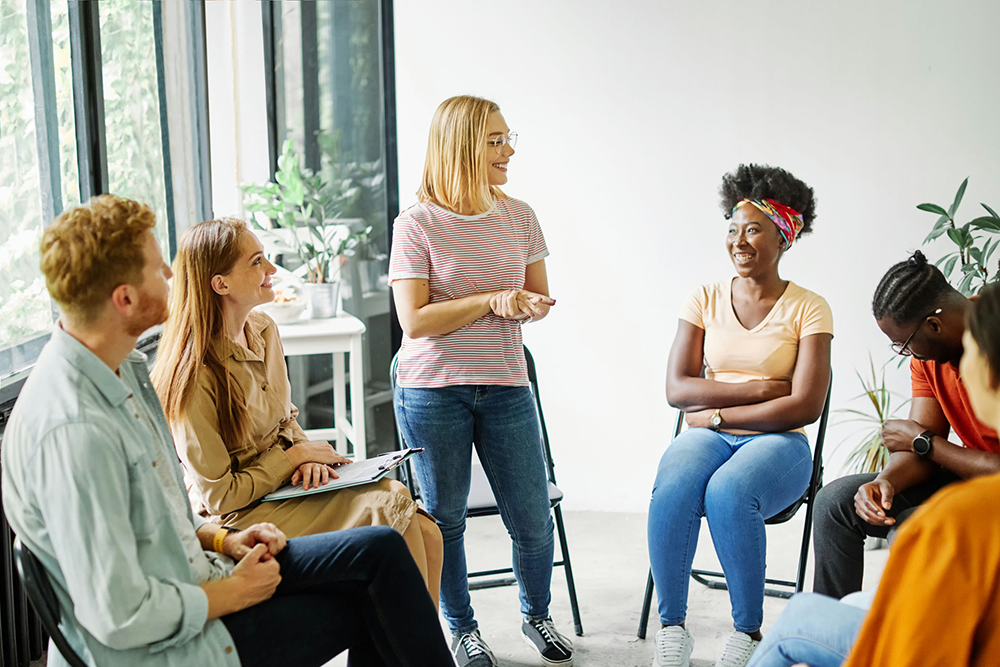 woman sharing with group during therapy