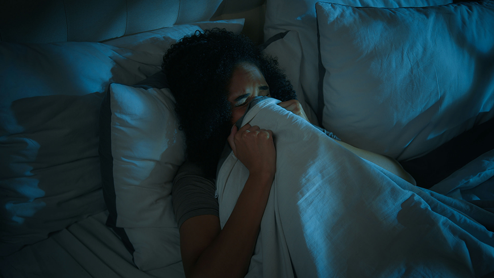 Person waking from a nightmare, symbolizing trauma-related flashbacks and disturbed sleep from PTSD