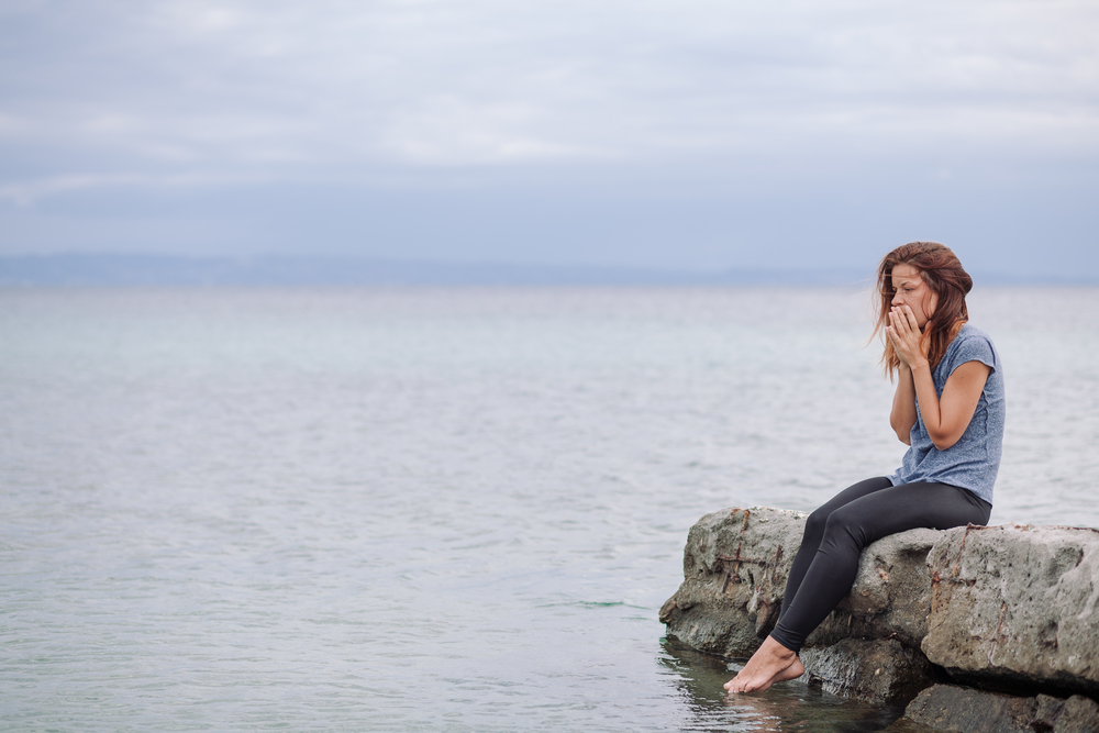 A girl seated by the seashore on her journey through dual diagnosis treatment