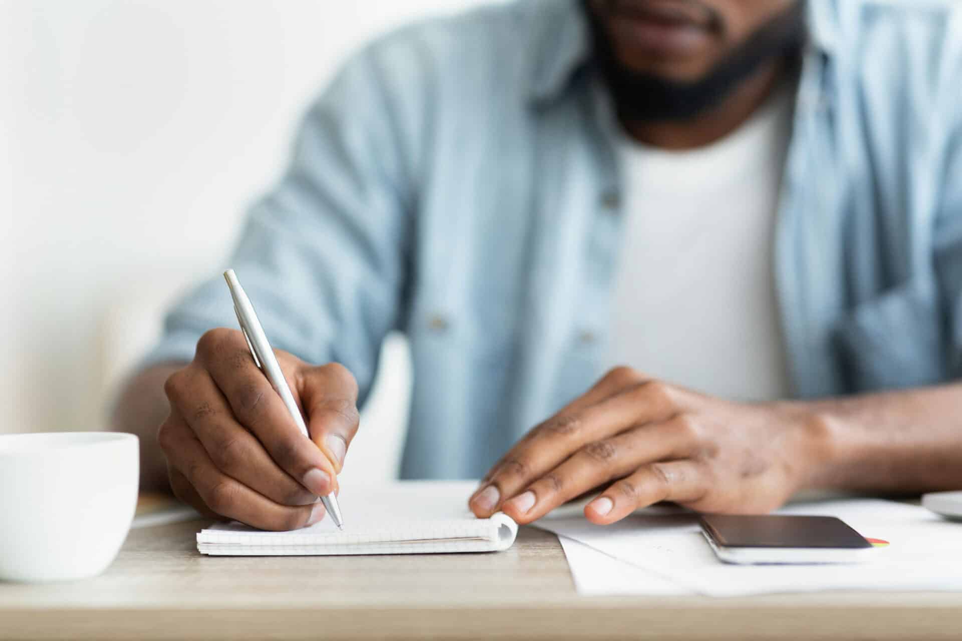 Person in addiction recovery journaling at home while learning coping with triggers during outpatient treatment