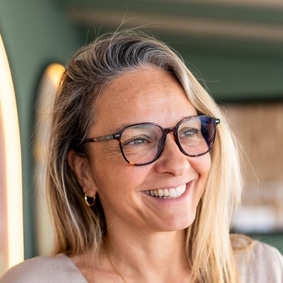 Smiling mature woman wearing glasses, looking away, reflecting on happiness